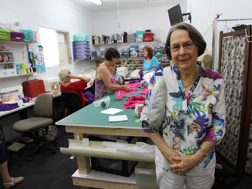 Berenice Payne stands in front of room of Zonta volunteers sewing