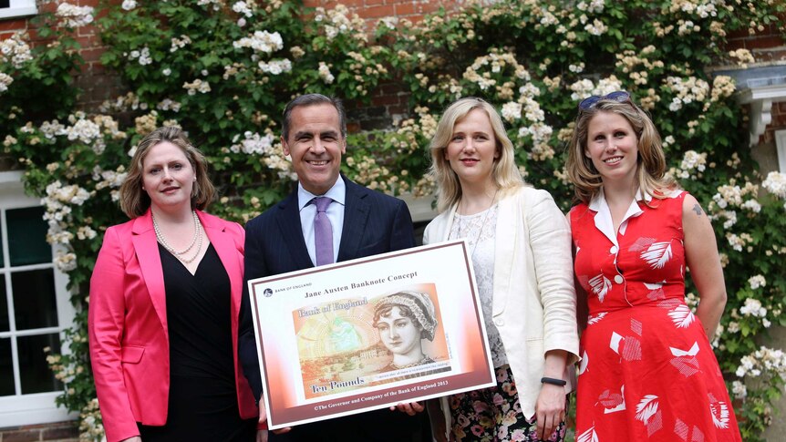 Campaigners pose next to a poster showing the design of the UK's next 10-pound note, which features Jane Austen.
