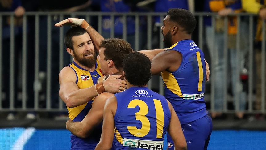 West Coast Eagles players jump all over Josh Kennedy after a match-winning AFL goal against Richmond.