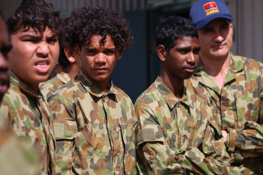 Four Indigenous boys in army uniforms.