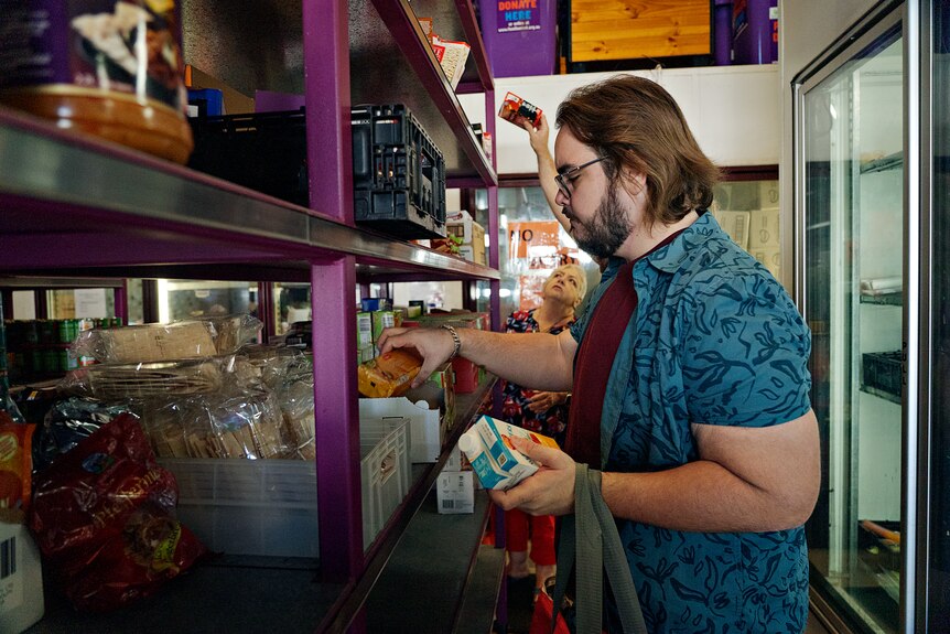 Deaclan Crowley shops for food in an aisle at Foodbank.