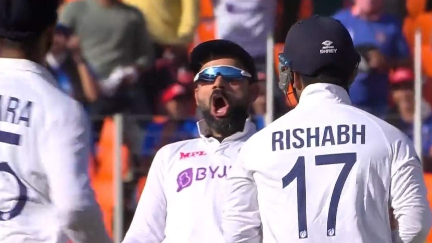 Virat Kohli leans back and opens his mouth screaming in celebration