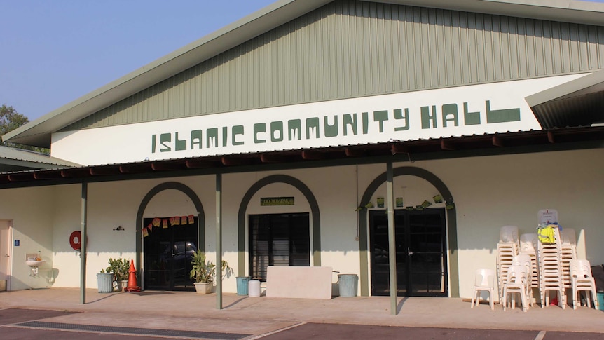 A cream coloured community hall with the words "Islamic Community Hall" written in dark green on the front.