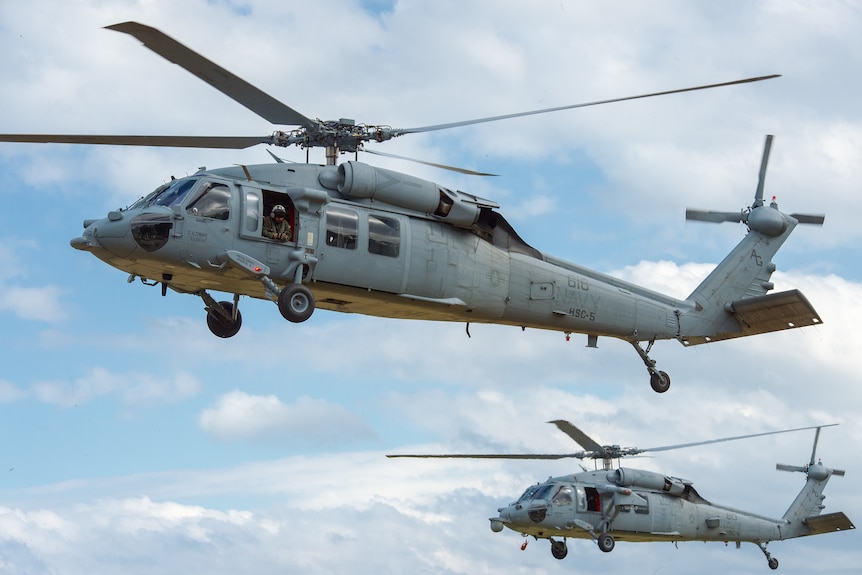 Two Sikorsky Seahawk helicopters in the sky during a NATO military exercise.