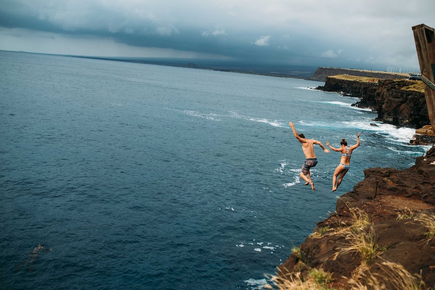 Man and woman cliff diving