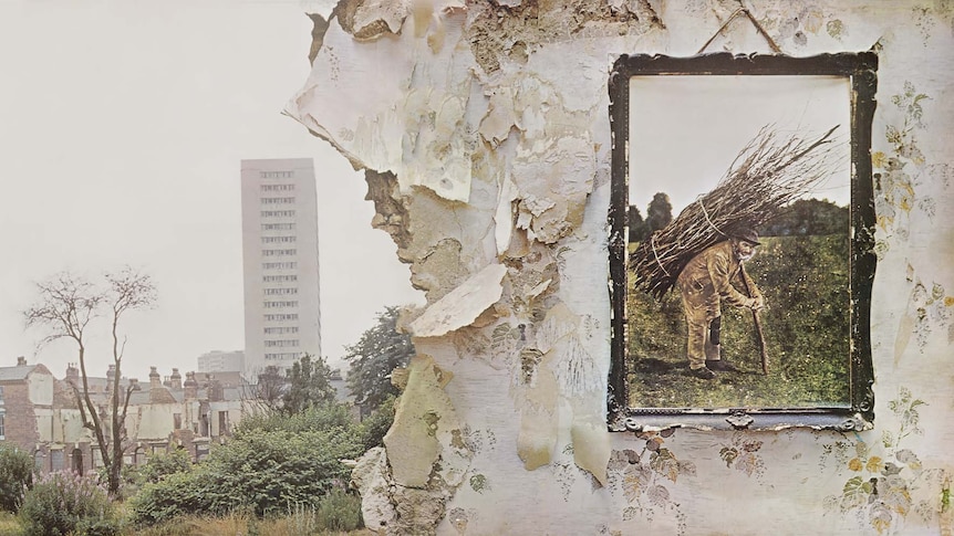 An old photo print hangs on a ruined wall in front of a city skyline
