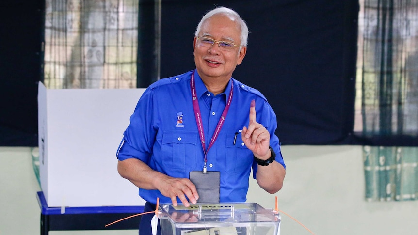 Malaysian Prime Minister Najib Razak smiles at a polling booth.