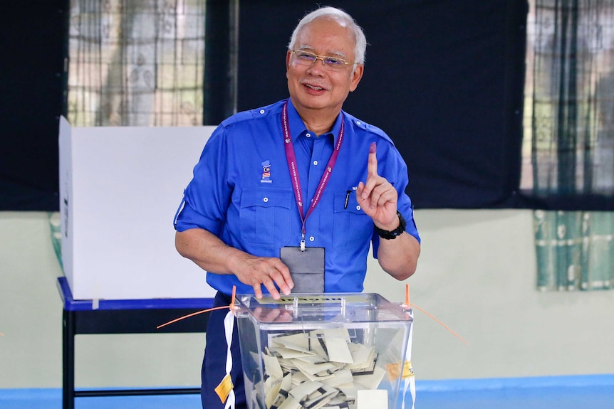 Malaysian Prime Minister Najib Razak smiles at a polling booth.