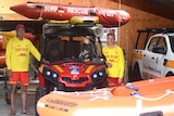 two surf life savers standing next to a rescue buggy