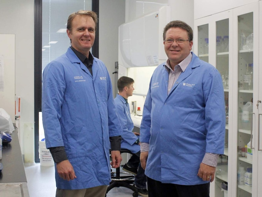 Dr Jade Forwood and Professor Shane Raidal stand side-by-side at a lab at Charles Sturt University in Wagga Wagga.