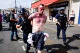Bloodied man being walked away from riot scene