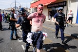 Bloodied man being walked away from riot scene