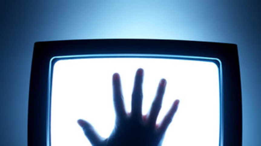 A hand placed on a television screen