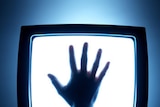 A hand placed on a television screen