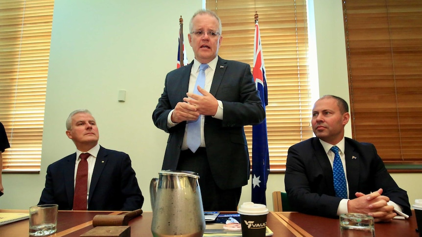 PM Scott Morrison looks uninspiring as he addresses the joint party room, flanked by DPM McCormack and Treasurer Frydenberg