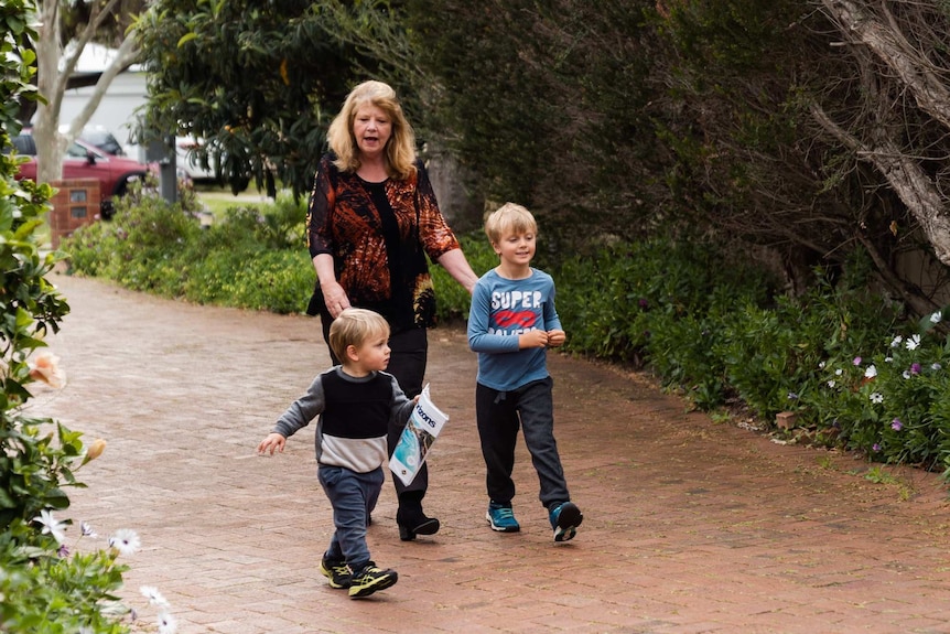 Shirley Dix with her grandsons Arlo and Beau walking on the driveway.