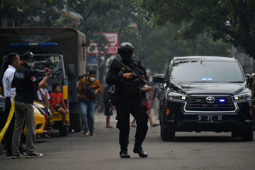 Policeman stands guard at the site of a blast at a police station in Bandung, West Java, Indonesia.