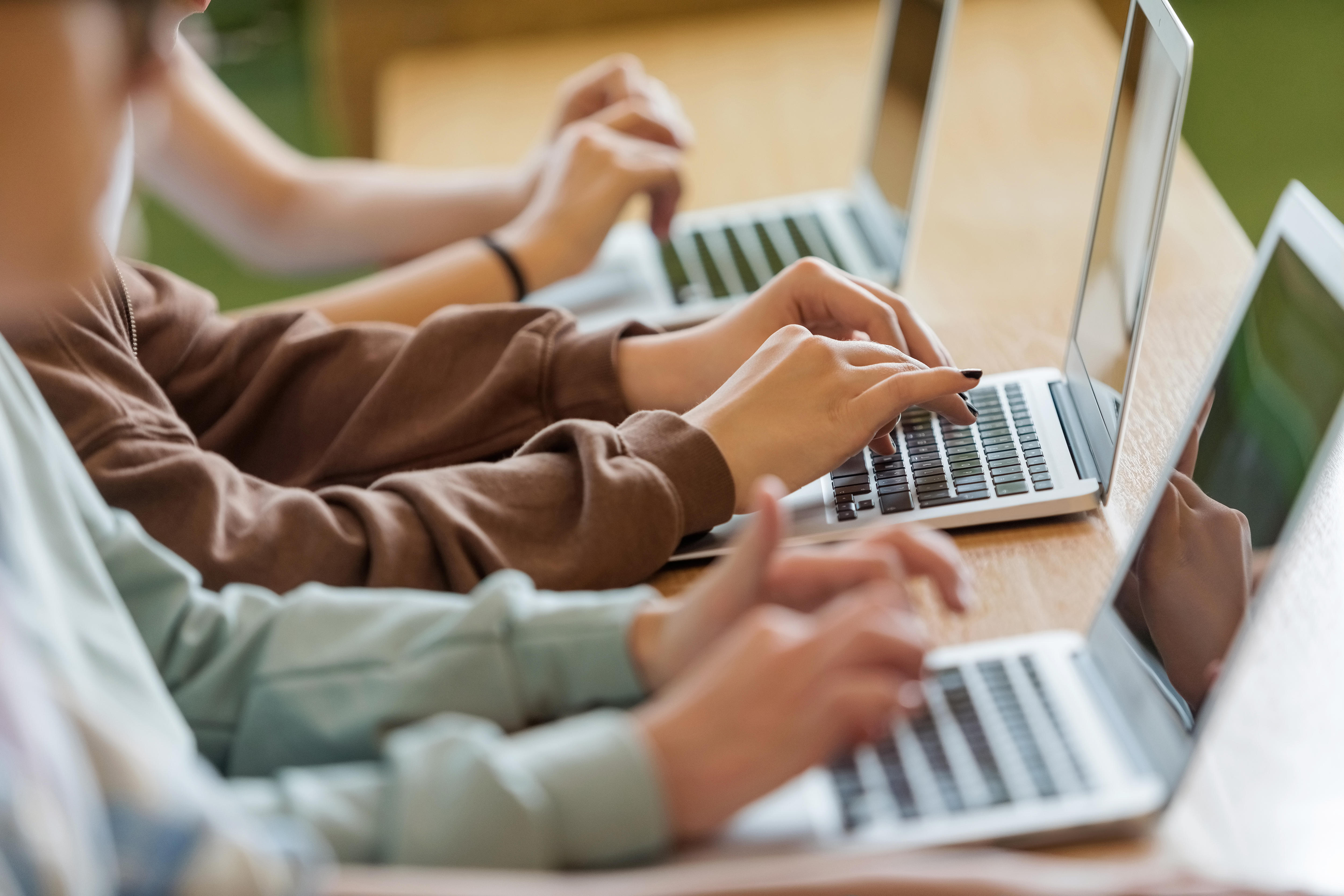 High school students sitting in a classroom using laptops
