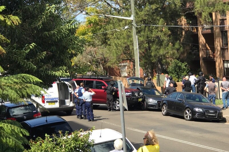 Police and bystanders at a road in Cremorne where police rammed a vehicle with four men inside