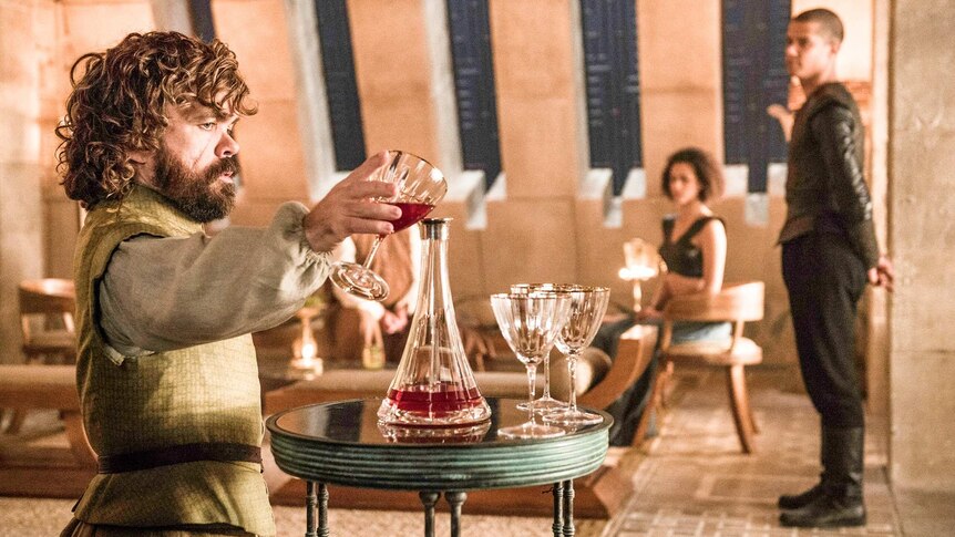 Tyrion Lannister in Game of Thrones season six pours a glass of wine.