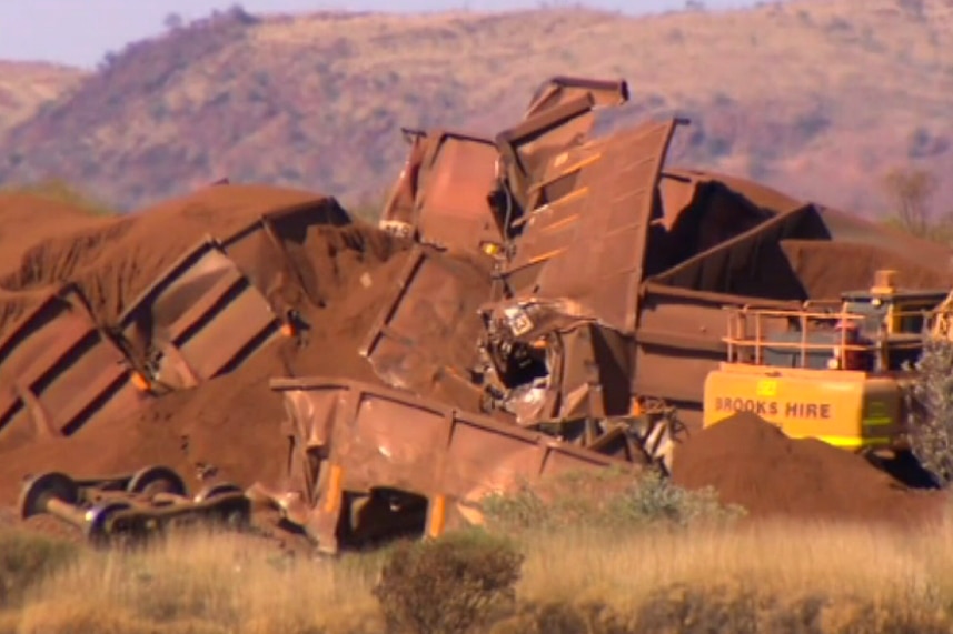 The mangled wreckage of a BHP iron ore train lies beside a rail line after it was deliberately derailed.