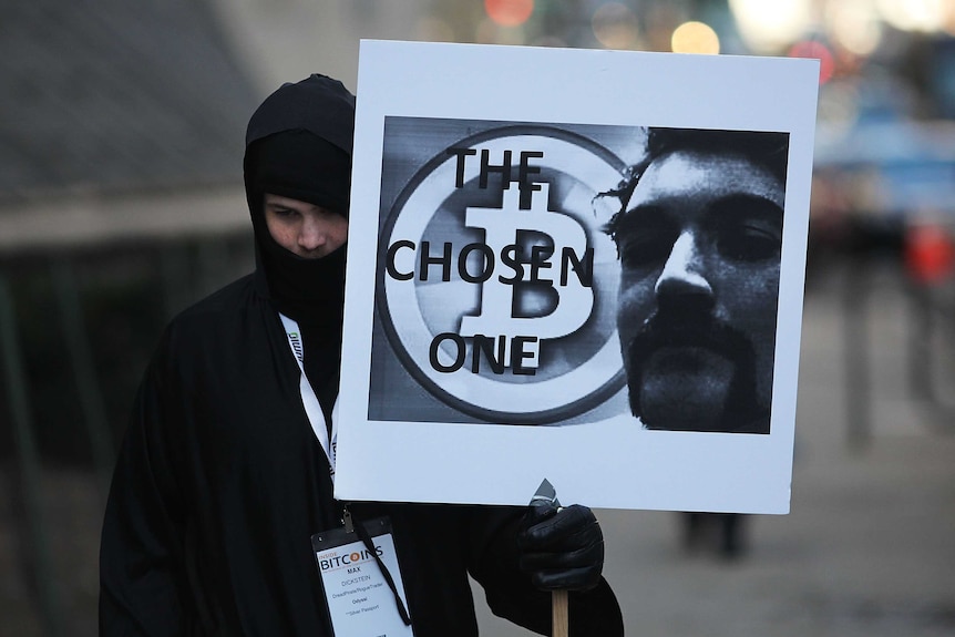 Supporters of Silk Road founder Ross Ulbricht hold posters outside his trial.