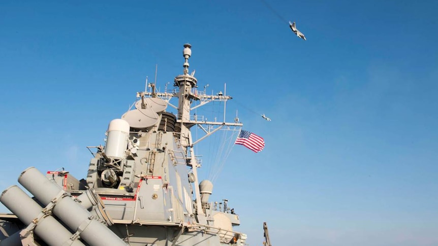 Two Russian aircraft fly over a US destroyer