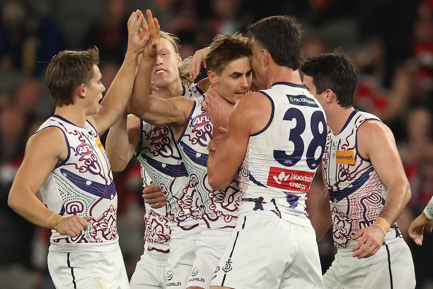Dockers players get around Jeremy Sharp in celebration of a goal