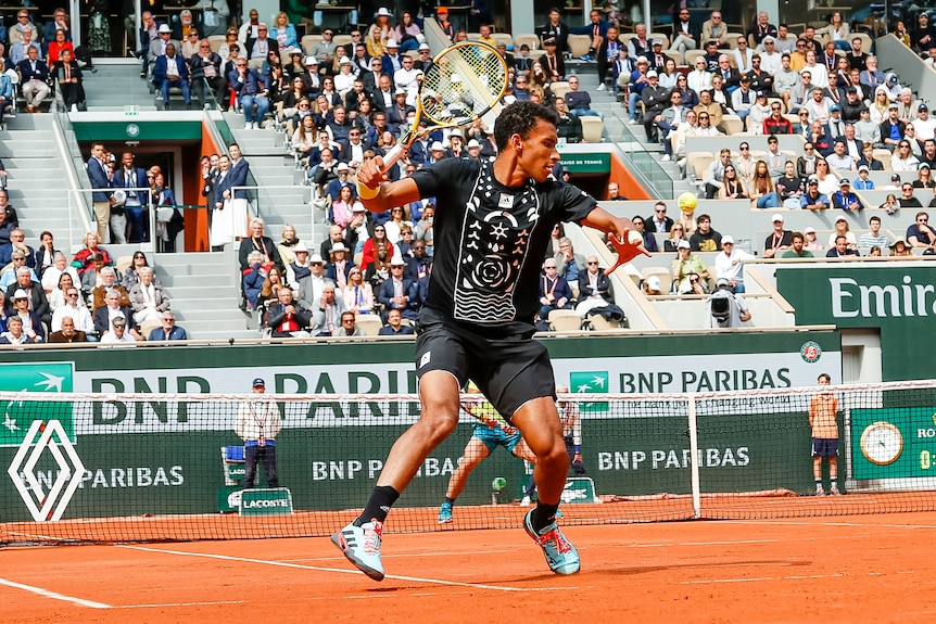 Félix Auger-Alissime watches the ball as he holds his racquet cocked before hitting a forehand at Roland-Garros.
