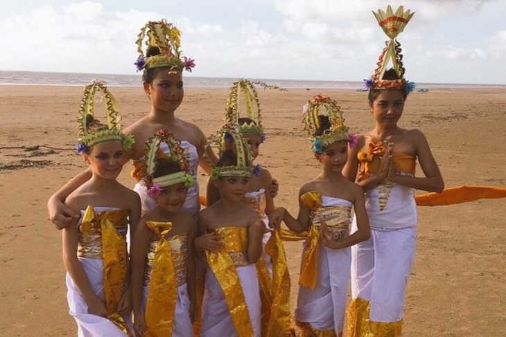 Balinese people dressed in traditional costumes on Casuarina beach for the Melasti cleansing ceremony.