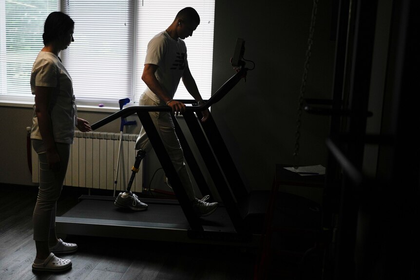 Amputated Ukrainian soldier standing on a treadmill machine 