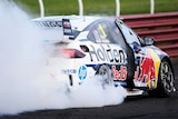 A racing car spins the rear wheels to create smoke.