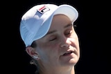 A female tennis player stands and looks disappointed at the Australian Open.