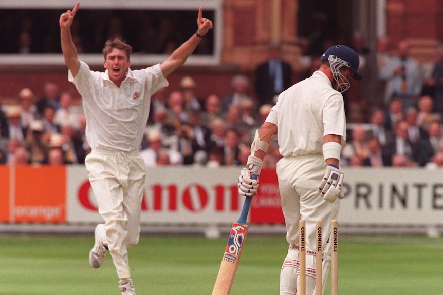 Glenn McGrath holds his arms in the air as Alex Stewart's bails are dislodged