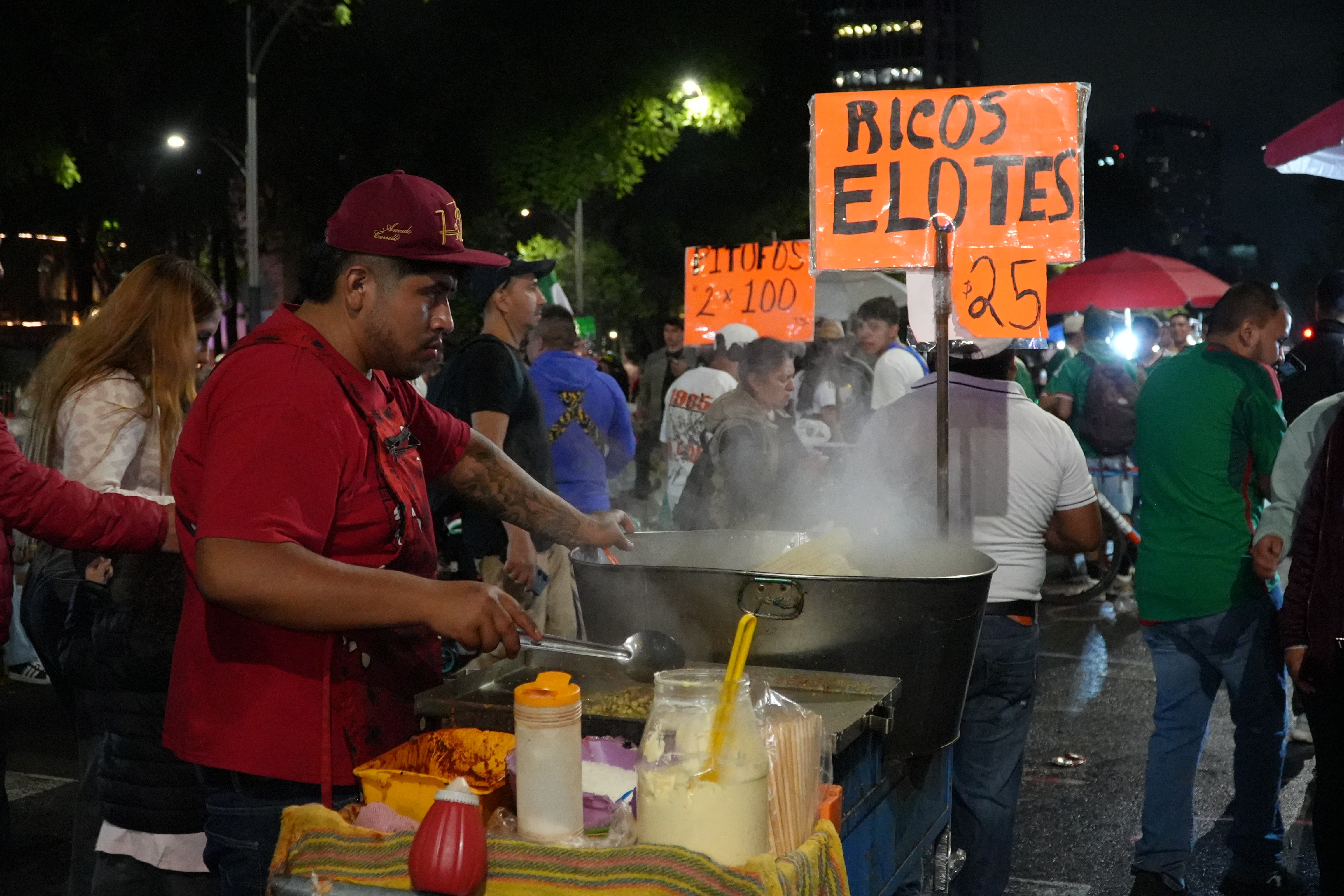 A male street vendor serves food. 