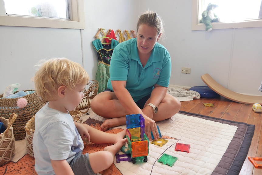 A woman and a child playing with some blocks