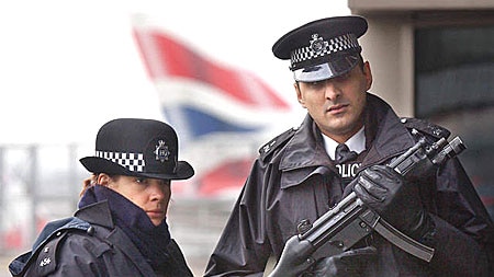 An armed British police officer patrols with a colleague at Heathrow Airport (file photo)