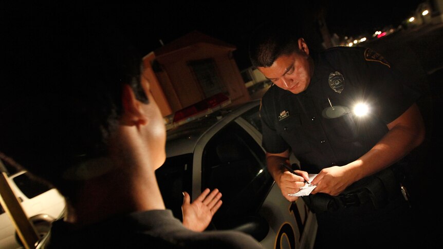 A Tucson police officer questions a boy.