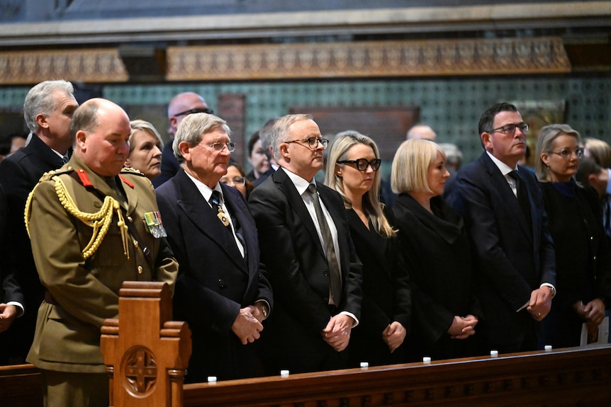 Daniel Andrews, Anthony Albanese and other in pews in a church 