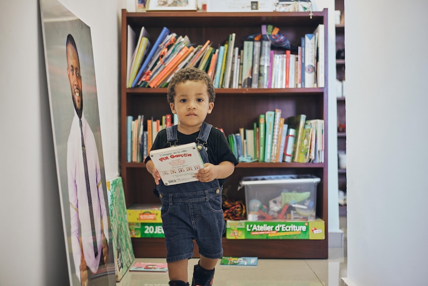 Géraldine's son runs up the hallways with a book in his hand