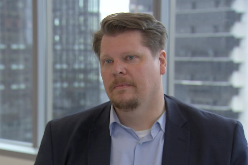 a man with short hair and a beard wearing a suit.