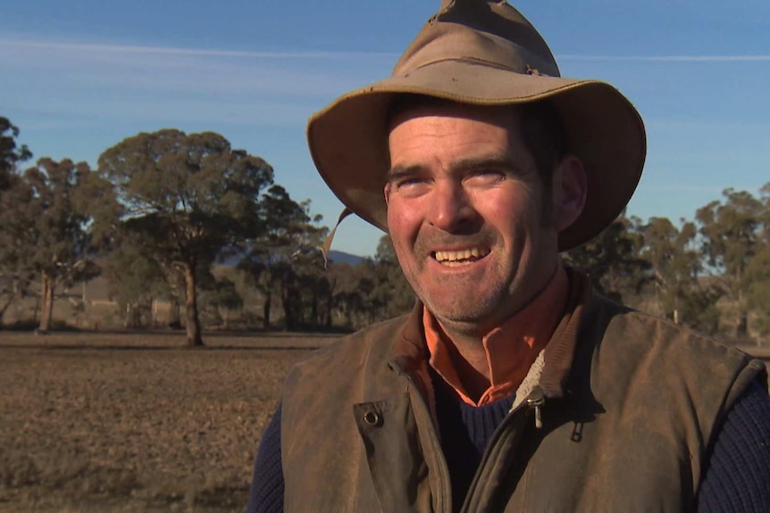A smiling farmer in his field talking to Sean Murphy about biosolids