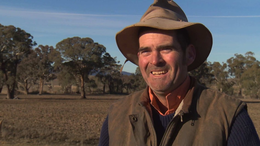 A smiling farmer in his field talking to Sean Murphy about biosolids