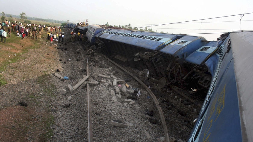 Indian rescue workers and volunteers survey the scene at a railway accident at Sardiha