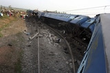 Indian rescue workers and volunteers survey the scene at a railway accident at Sardiha