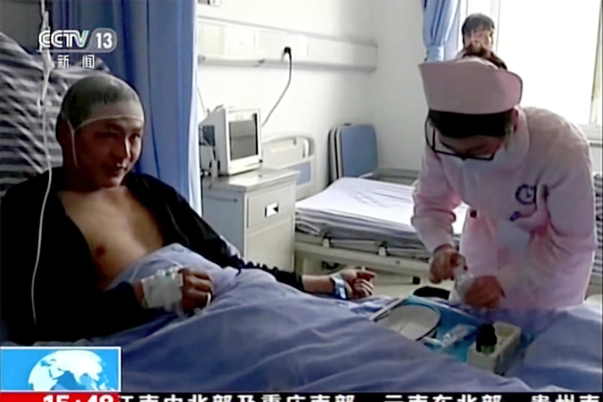 Nurses attend to a patient in a chinese hospital bed