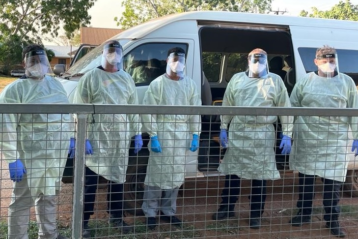 An NT Health team in a remote community stand in front of a van.