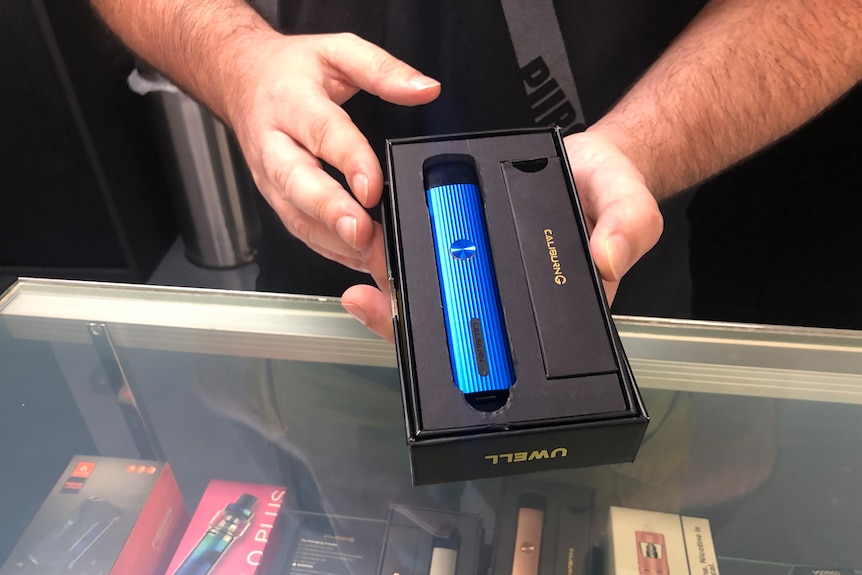 Two hands holding a box with a vape inside