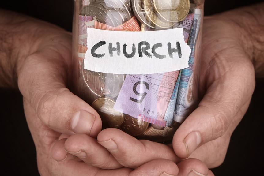 A jar with Church written on it full of money.