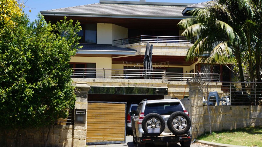 A fancy house with a car parked out the front.